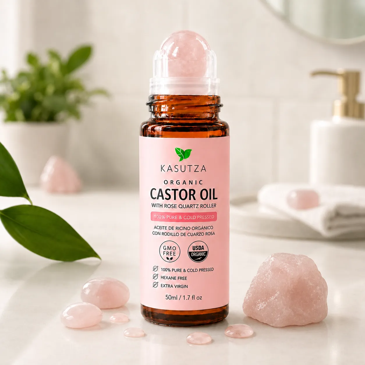 KASUTZA amber castor oil roll-on with a rose quartz roller on a bathroom counter